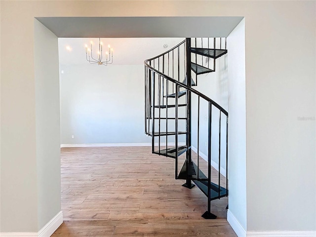 stairs featuring a chandelier and hardwood / wood-style floors