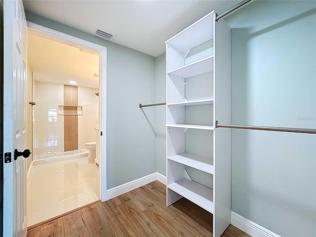 spacious closet with hardwood / wood-style flooring