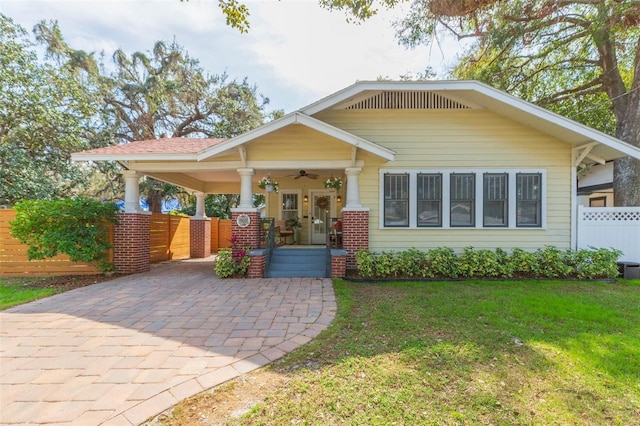 view of front of property with ceiling fan, a porch, and a front yard