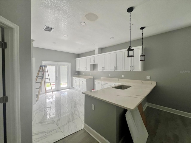 3413 N 72nd St, Tampa, FL 33619 - kitchen with white cabinetry, baseboards, a peninsula, hanging light fixtures, and a breakfast bar area