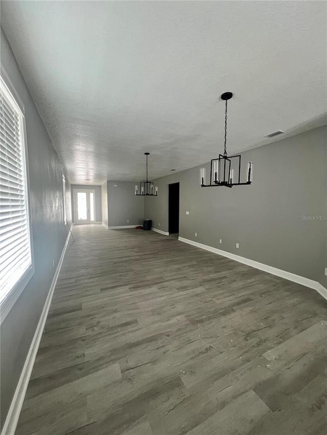3413 N 72nd St, Tampa, FL 33619 - unfurnished living room featuring a chandelier, wood finished floors, baseboards, and a textured ceiling