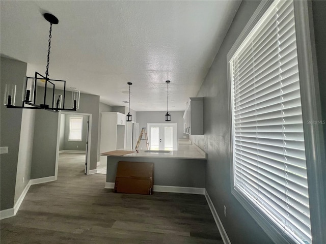 3413 N 72nd St, Tampa, FL 33619 - kitchen with a peninsula, a chandelier, dark wood finished floors, baseboards, and pendant lighting