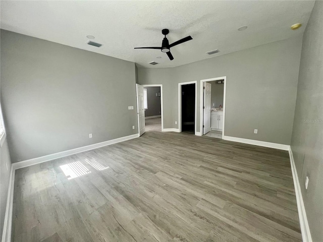 3413 N 72nd St, Tampa, FL 33619 - unfurnished bedroom with wood finished floors, baseboards, ensuite bath, and a ceiling fan
