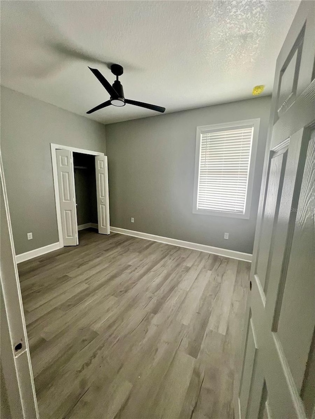 3413 N 72nd St, Tampa, FL 33619 - unfurnished bedroom with wood finished floors, a textured ceiling, baseboards, and a closet