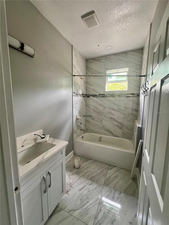 3413 N 72nd St, Tampa, FL 33619 - full bathroom with vanity, washtub / shower combination, a textured ceiling, and marble finish floors