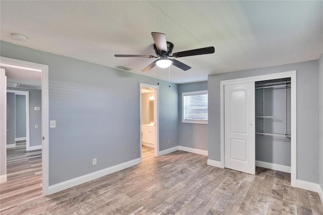 unfurnished bedroom with light wood-style floors, baseboards, and a closet