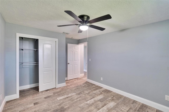 unfurnished bedroom with visible vents, a closet, light wood-style flooring, and baseboards