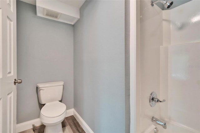 full bath featuring baseboards, visible vents, toilet, wood finished floors, and  shower combination