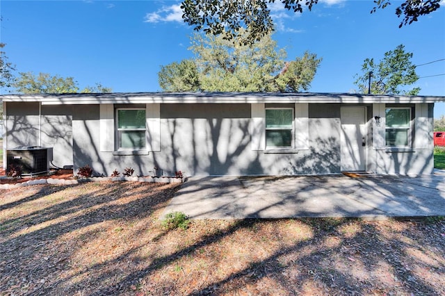 rear view of property featuring a patio area, cooling unit, and stucco siding