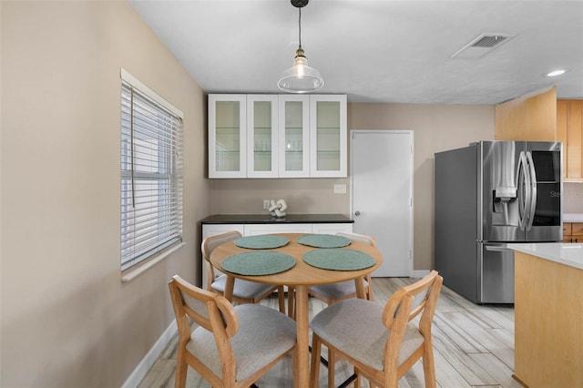 kitchen with visible vents, glass insert cabinets, light wood-style floors, smart refrigerator, and pendant lighting