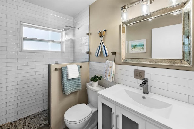 bathroom featuring tile walls, vanity, toilet, and a walk in shower