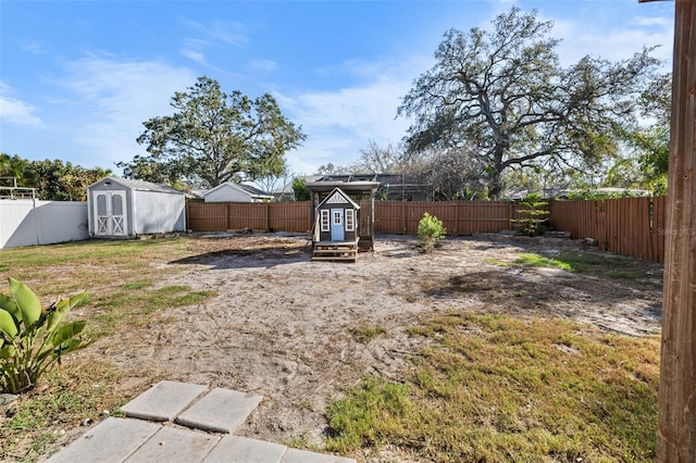 view of yard with a fenced backyard, an outdoor structure, and a storage shed