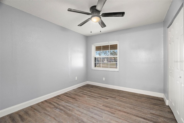 empty room featuring dark hardwood / wood-style flooring and ceiling fan