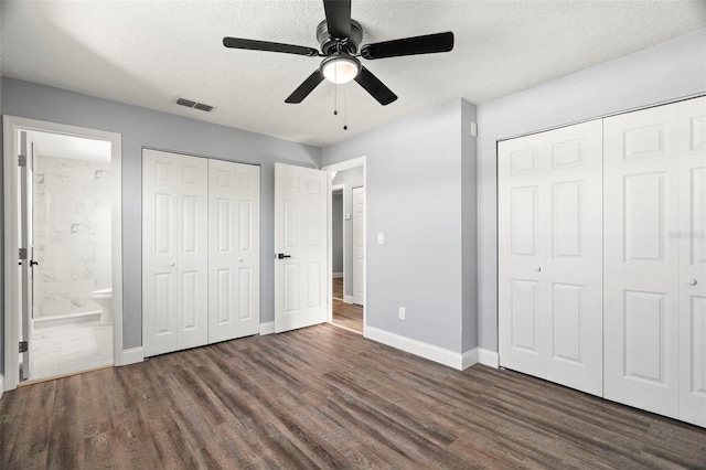 unfurnished bedroom with ensuite bathroom, dark hardwood / wood-style floors, and a textured ceiling