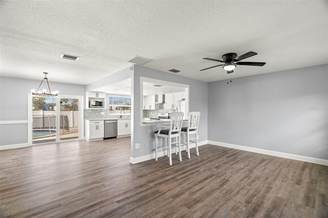 unfurnished living room with sink, ceiling fan with notable chandelier, a textured ceiling, and dark hardwood / wood-style flooring