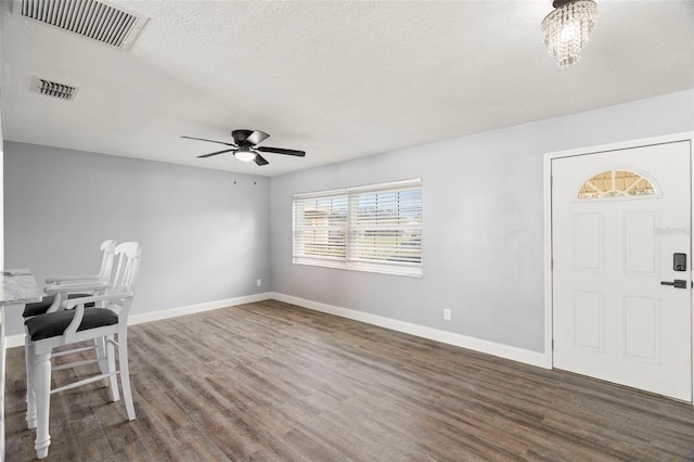 foyer with ceiling fan, dark hardwood / wood-style floors, and a textured ceiling