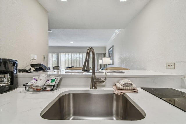 details featuring ornamental molding, light stone countertops, sink, and black electric stovetop