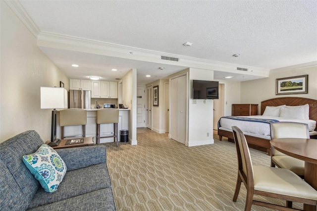 interior space featuring ornamental molding, stainless steel refrigerator, and a textured ceiling