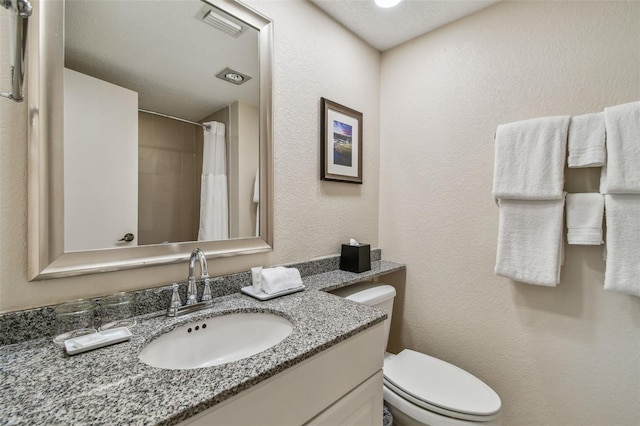 bathroom with vanity, walk in shower, and toilet