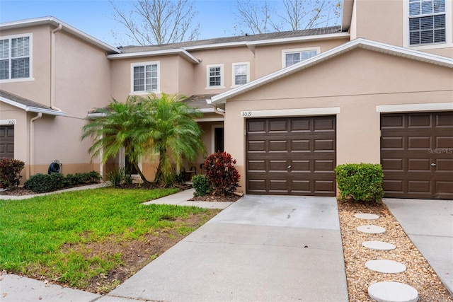 multi unit property featuring a garage and a front lawn