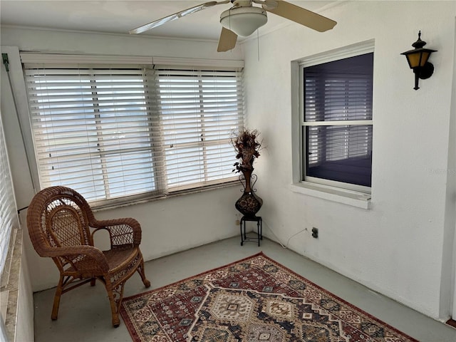 sitting room featuring concrete flooring and ceiling fan