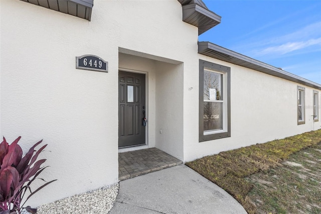 view of exterior entry featuring stucco siding