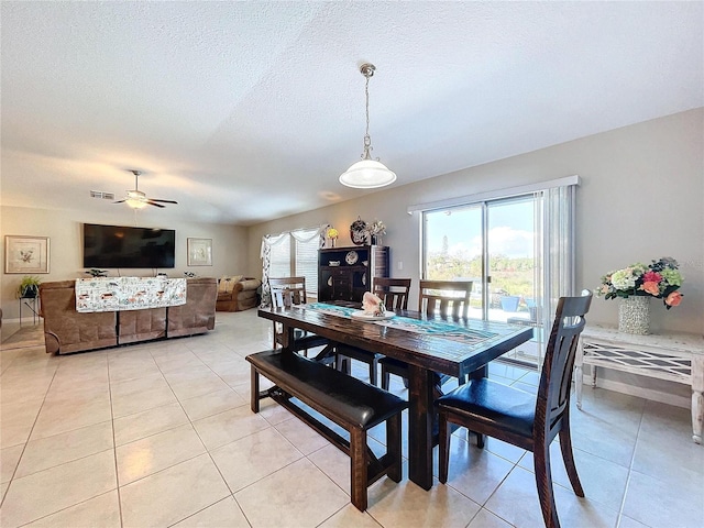 dining room with ceiling fan, a textured ceiling, and light tile patterned floors