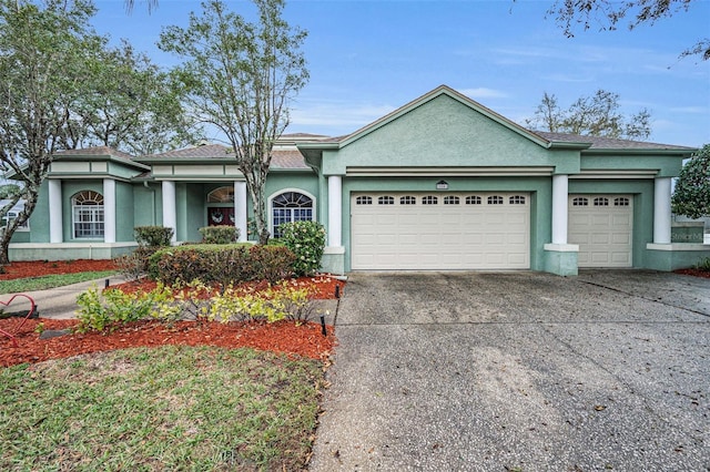 view of front of property featuring a garage, driveway, and stucco siding