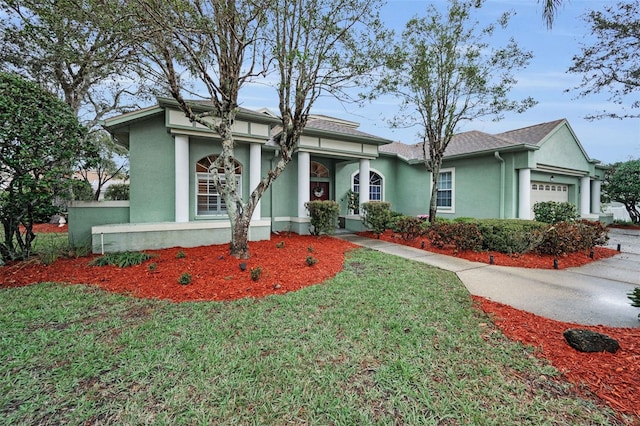 view of front facade with a front lawn, an attached garage, and stucco siding