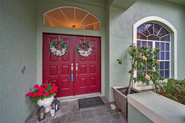 view of exterior entry with stucco siding