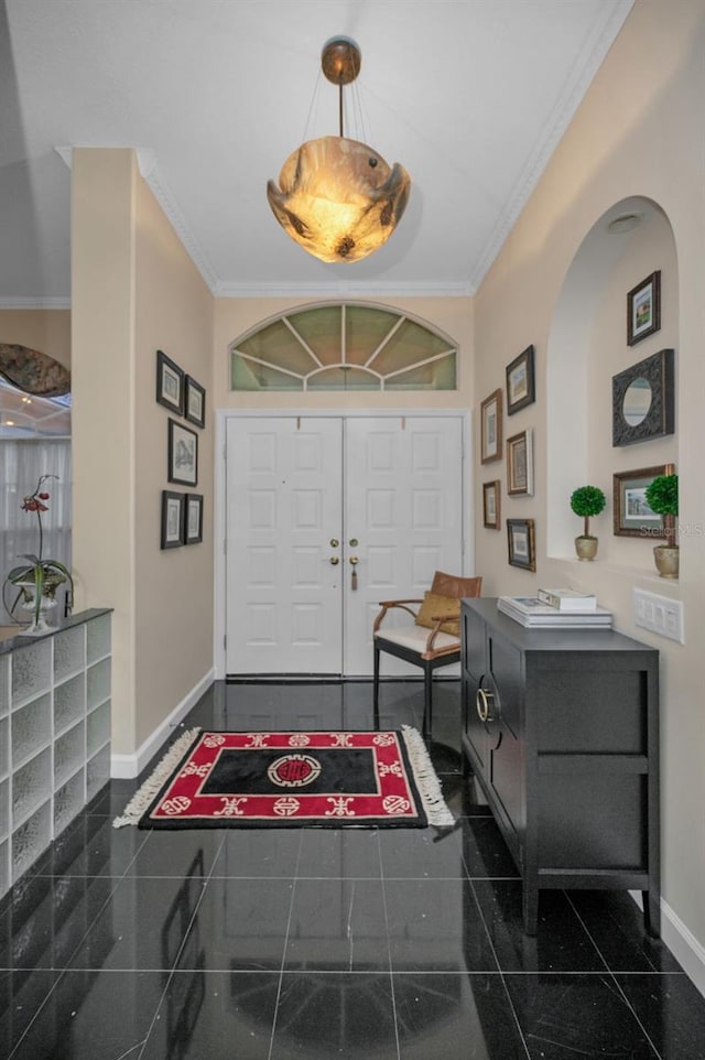 foyer with granite finish floor, baseboards, and ornamental molding