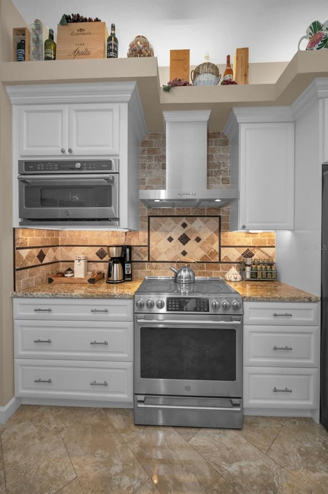 kitchen featuring stainless steel appliances, white cabinetry, backsplash, and wall chimney exhaust hood