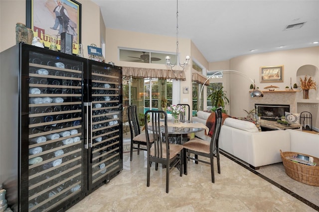 dining area with a glass covered fireplace, visible vents, and wine cooler