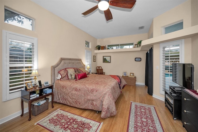 bedroom with light wood-type flooring, visible vents, ceiling fan, and baseboards