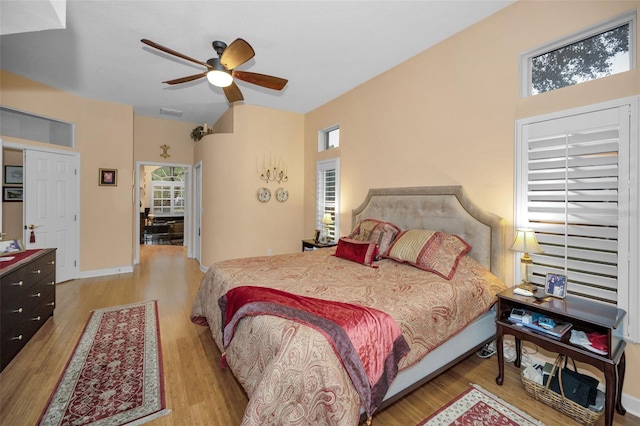 bedroom with a ceiling fan, light wood-style flooring, and baseboards