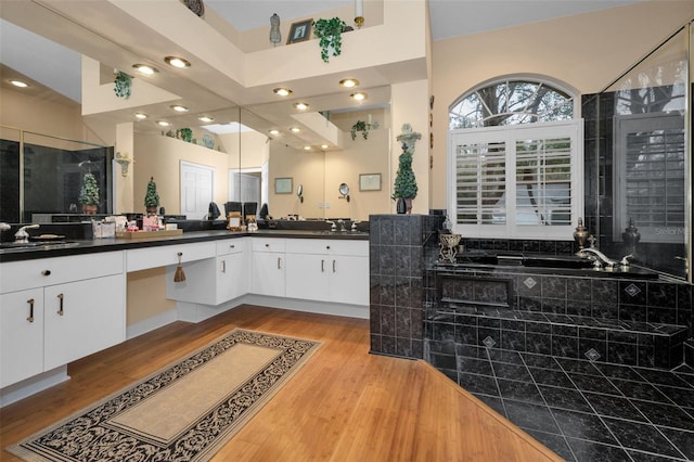 full bathroom featuring a garden tub, recessed lighting, a stall shower, vanity, and wood finished floors