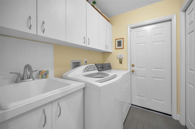 washroom featuring cabinet space, a sink, and independent washer and dryer