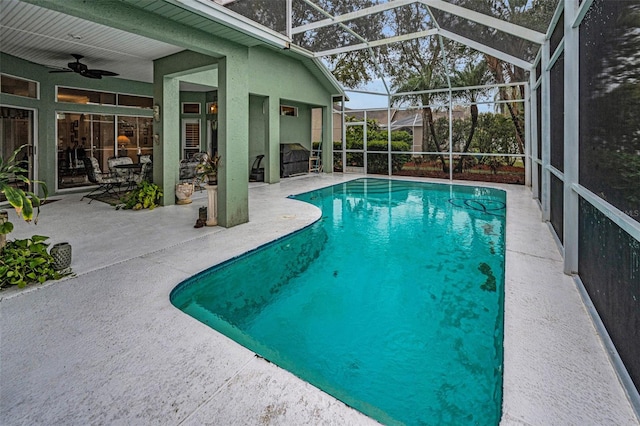 pool with glass enclosure, ceiling fan, and a patio