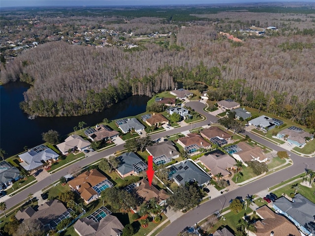 aerial view featuring a water view, a wooded view, and a residential view