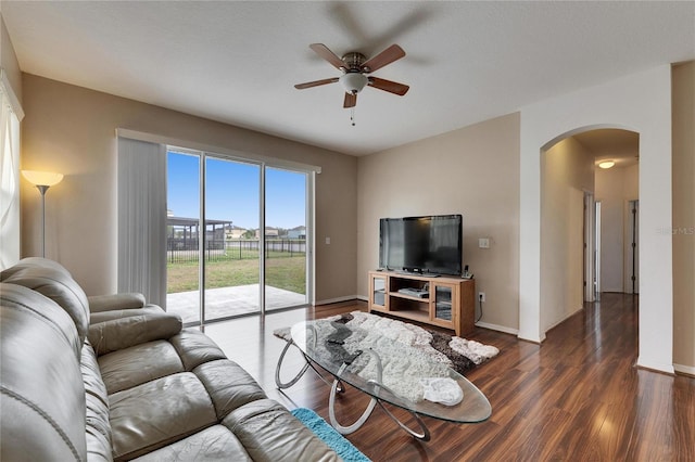 living room with dark wood-type flooring and ceiling fan