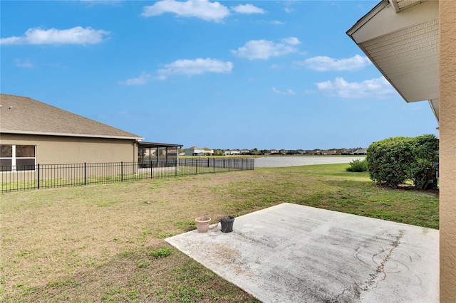 view of yard featuring a patio, a water view, and a sunroom