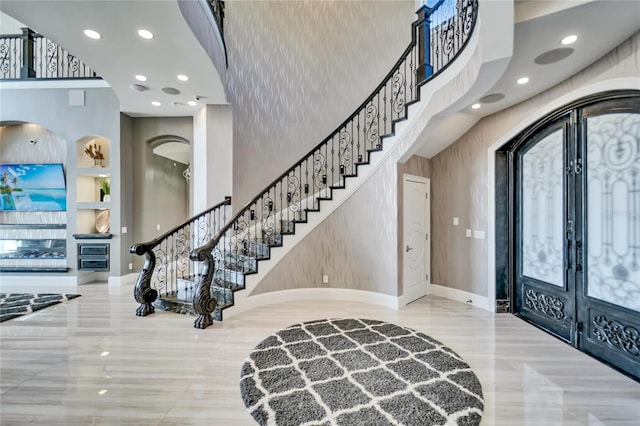 entryway with baseboards, stairway, a high ceiling, french doors, and recessed lighting