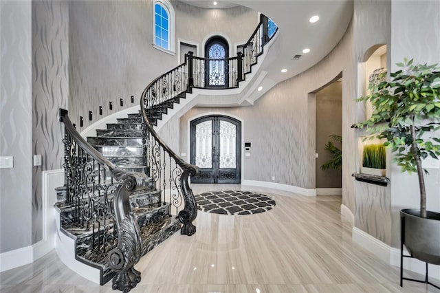 entryway featuring arched walkways, french doors, stairway, and a high ceiling