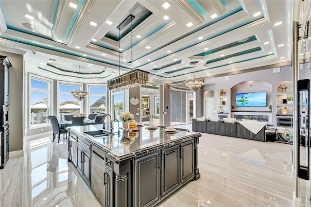 kitchen with open floor plan, crown molding, a sink, and a notable chandelier