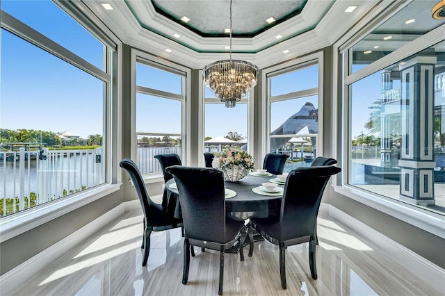 sunroom / solarium featuring a water view and an inviting chandelier