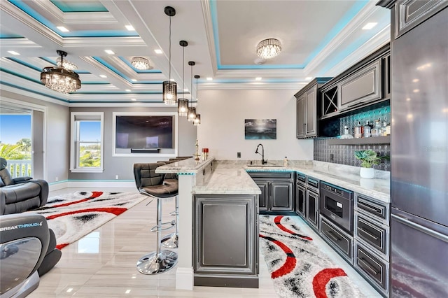 kitchen featuring a peninsula, stainless steel appliances, a sink, and open floor plan