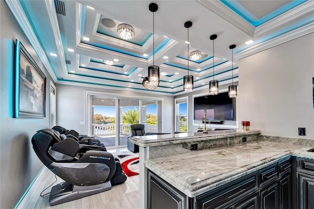 kitchen featuring dark cabinets, a peninsula, open floor plan, light stone countertops, and crown molding