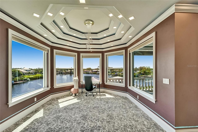 unfurnished sunroom featuring a raised ceiling, a water view, and plenty of natural light