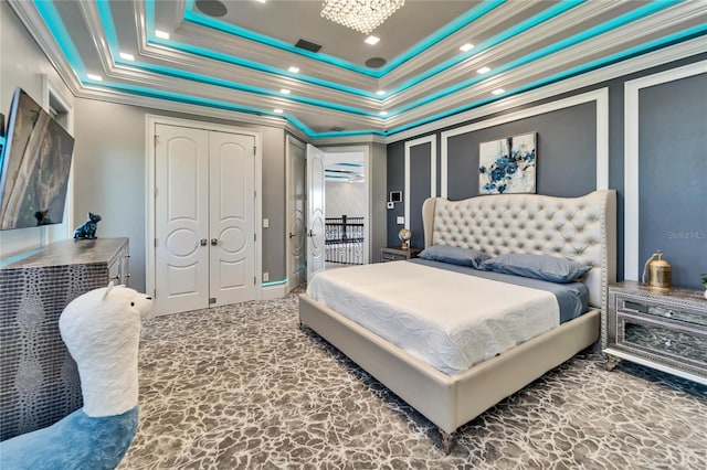 bedroom with a tray ceiling, a notable chandelier, crown molding, visible vents, and stone finish floor