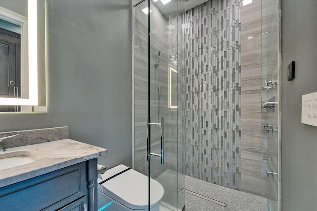 full bathroom featuring a shower stall, toilet, and vanity